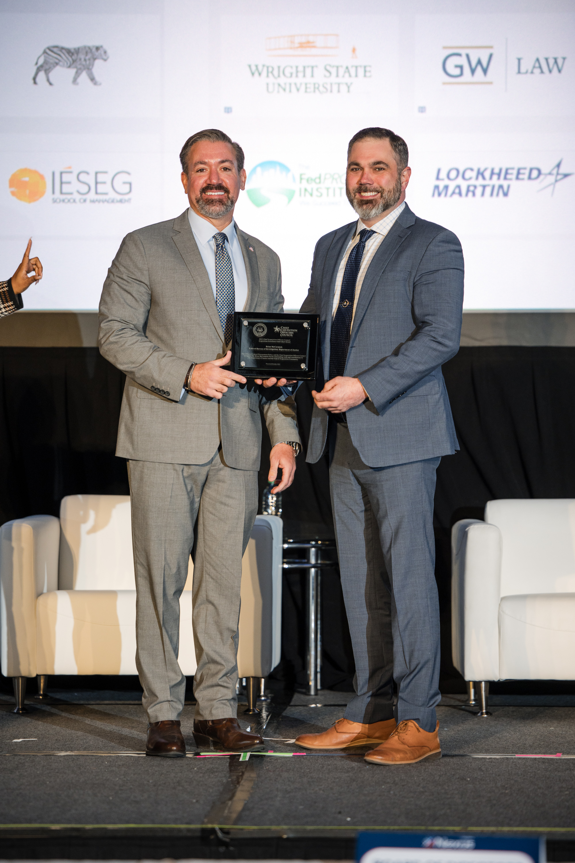 Dr. Kevin Rhodes, Administrator of the Office of Federal Procurement Policy (left), presents Brian McCormick (right), with the Acquisition Excellence Individual Award.